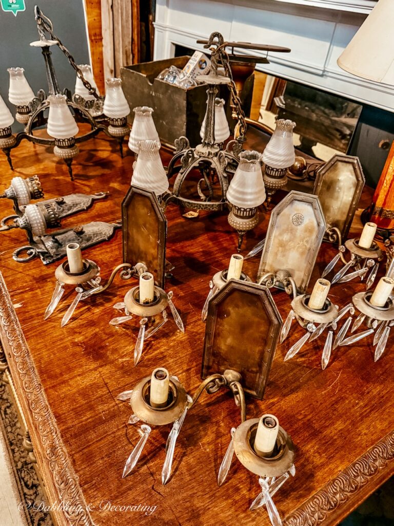 Antique wall sconces at The Old House Parts Co on display on an antique table.