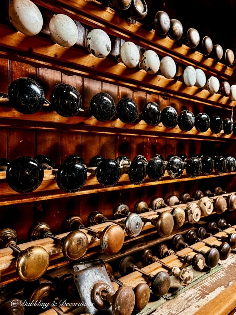 Cabinet filled with organized antique door knobs.