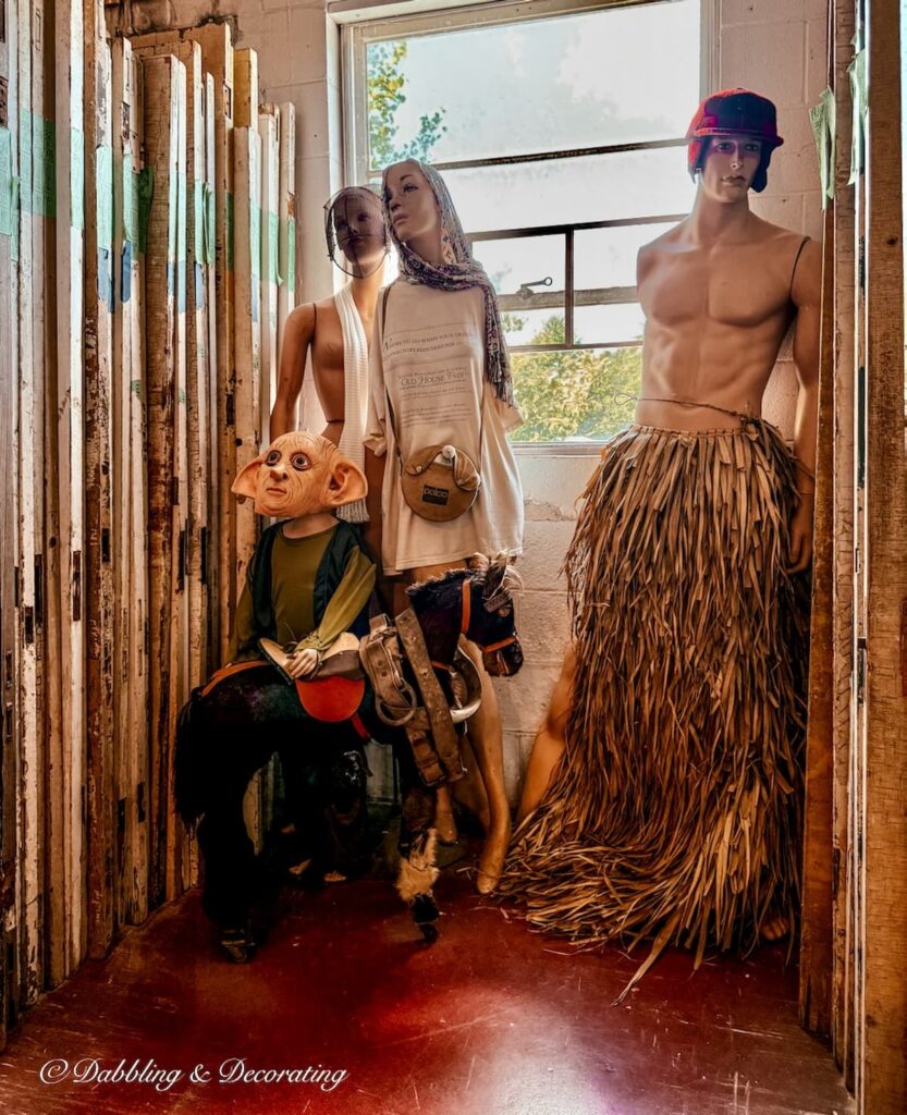 Four mannequins dressed up with masks and beach ware surrounded by architectural salvage at The Old House Parts Co.
