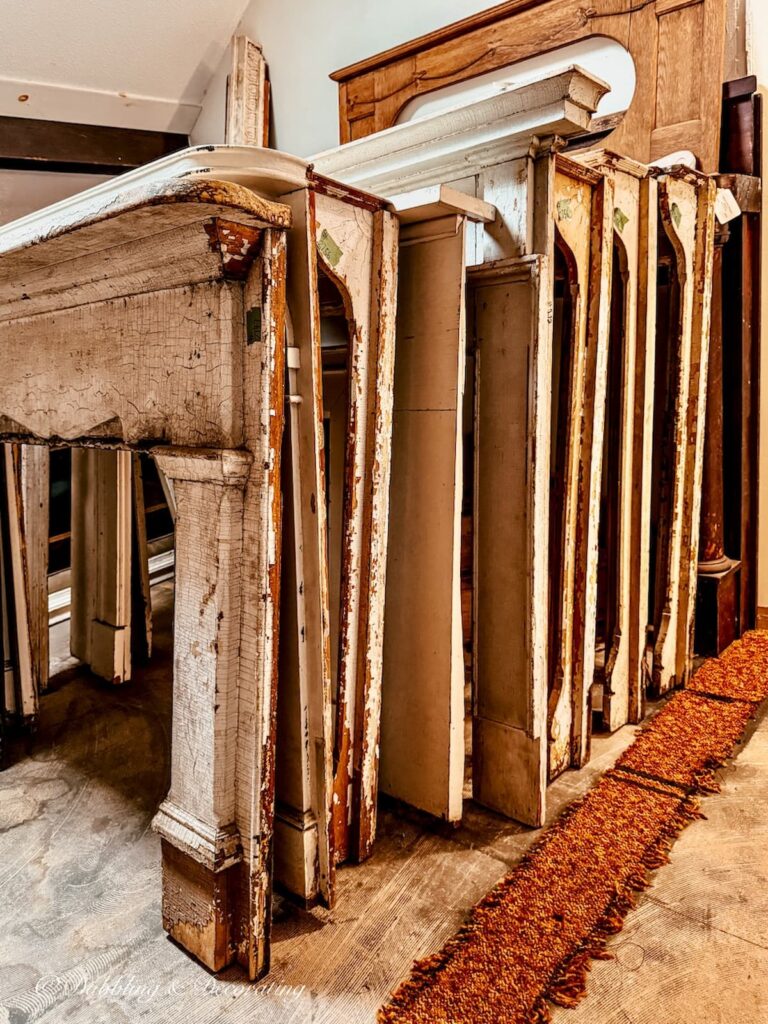 Collection of salvaged mantels lined up in all shapes, sizes, and ages at The Old House Parts Co.