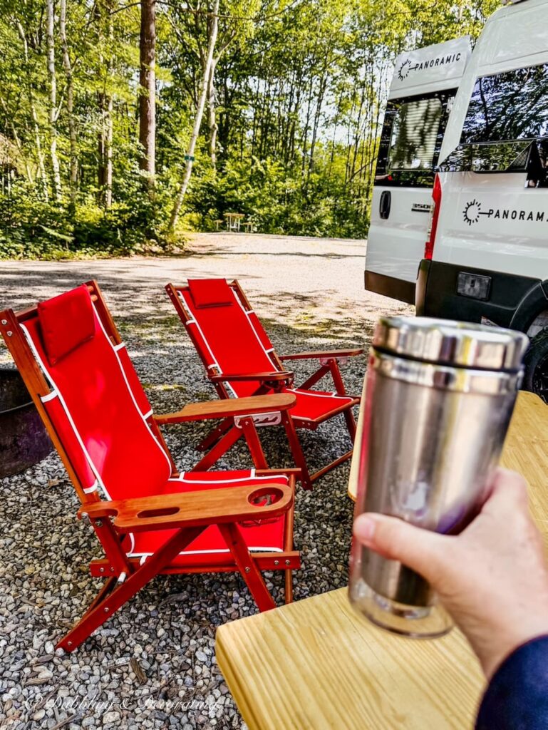 Two red teak camping chairs at Sandy Pines Campground at campsite in Maine.