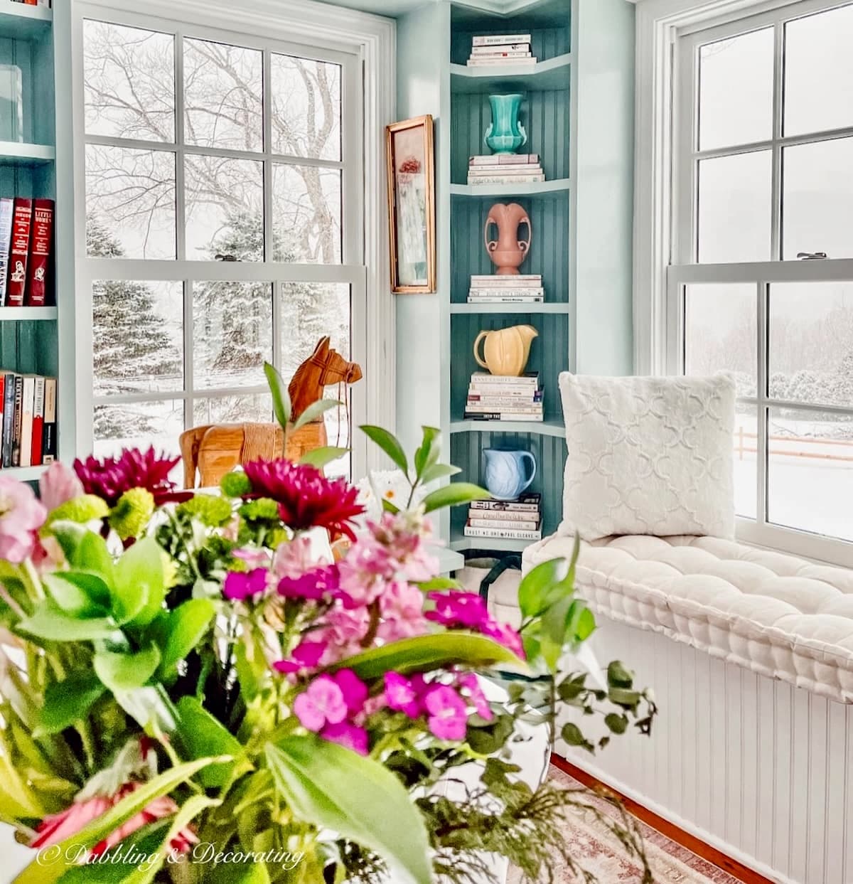 Vintage bookshelf decor with vintage McCoy vases, thrifted gift ideas in built-in shelving with spring flowers in Vermont home during cozy snow day at home. Cozy nostalgic winter decor ideas.