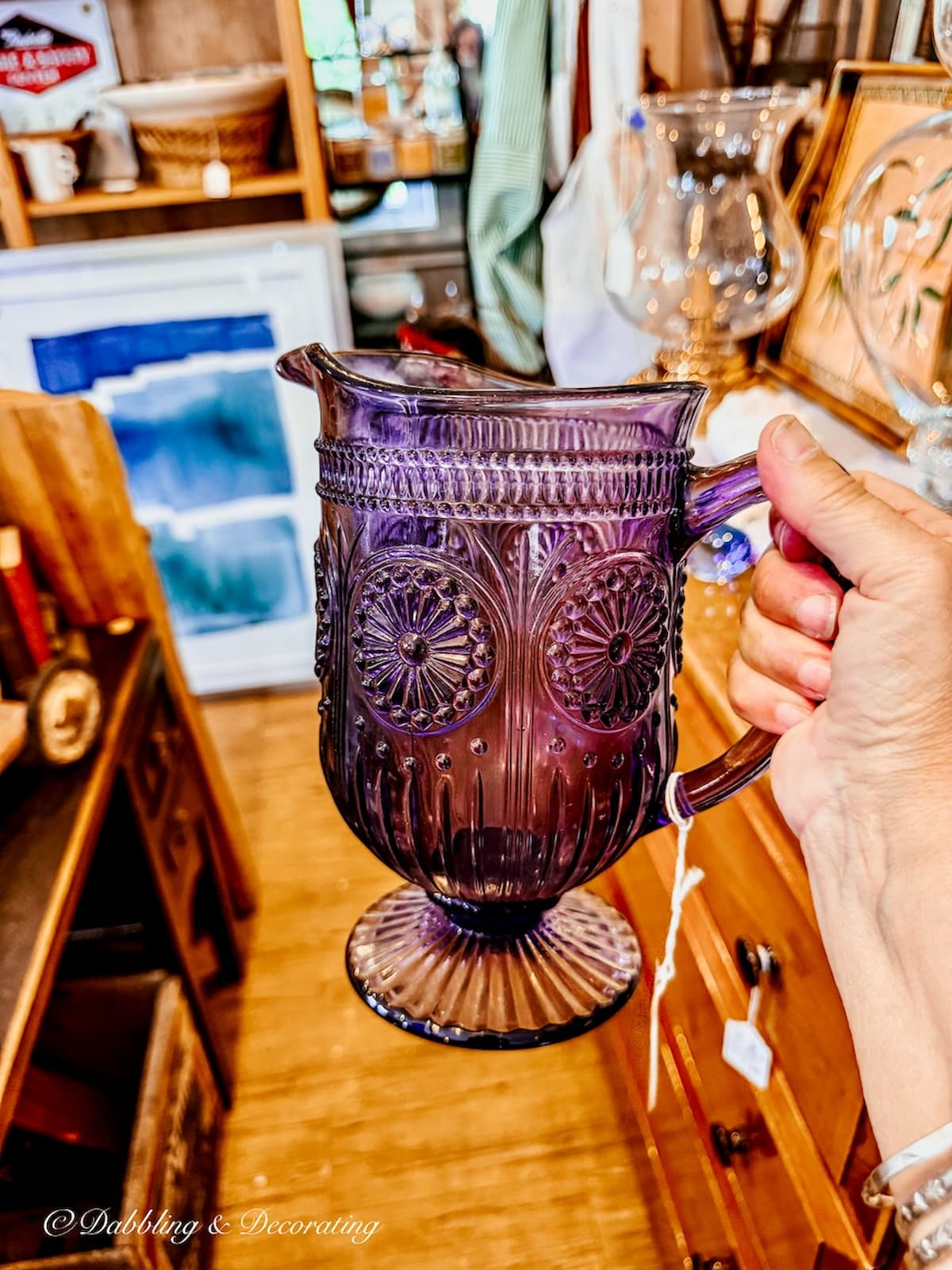 Amethyst antique glass pitcher in hand at antique store. Fall vintage finds