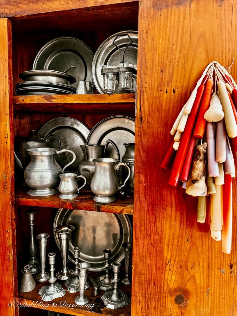 Antique wooden hutch with pewter collection styled with layering and collections in Early American New England home.