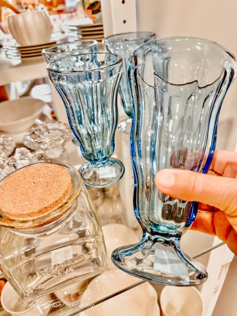 Vintage blue glass in hand at antique store.