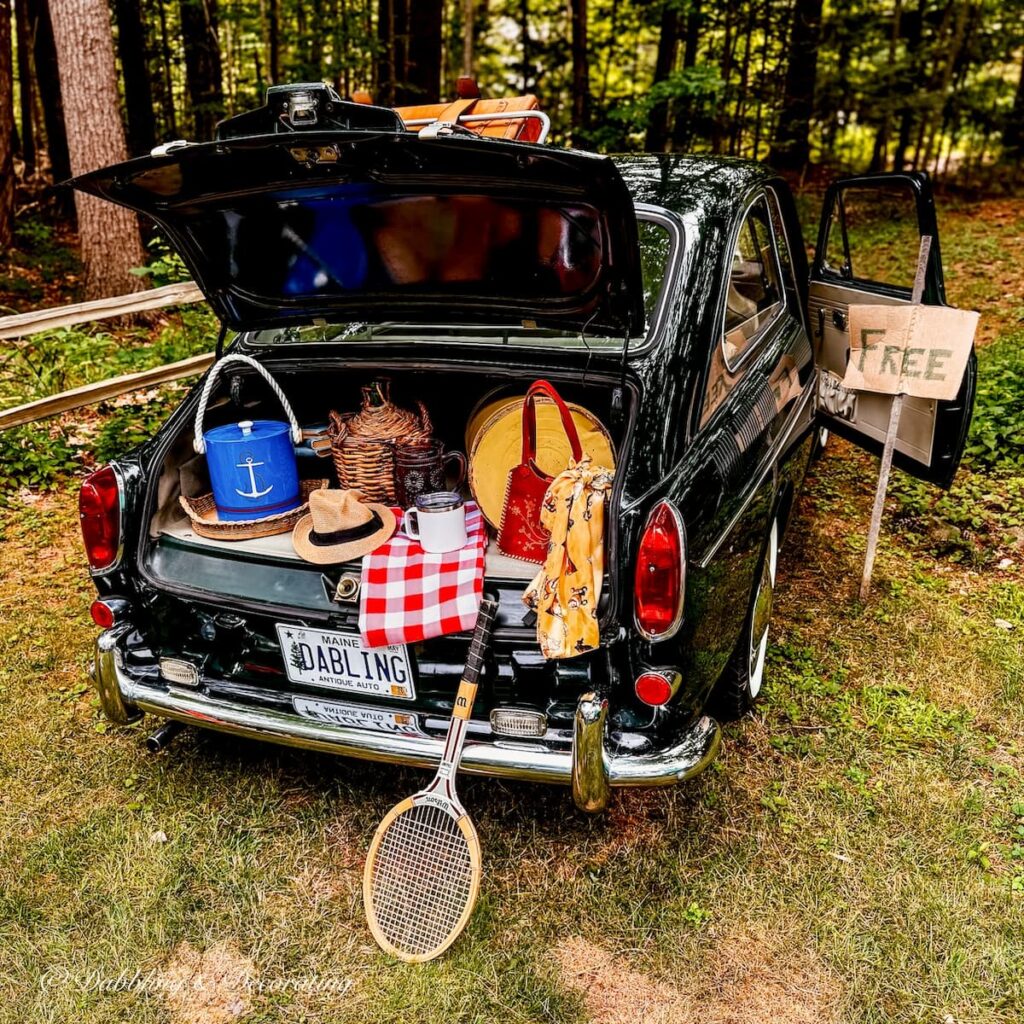 Vintage car with trunk open with thrift store road trip finds.