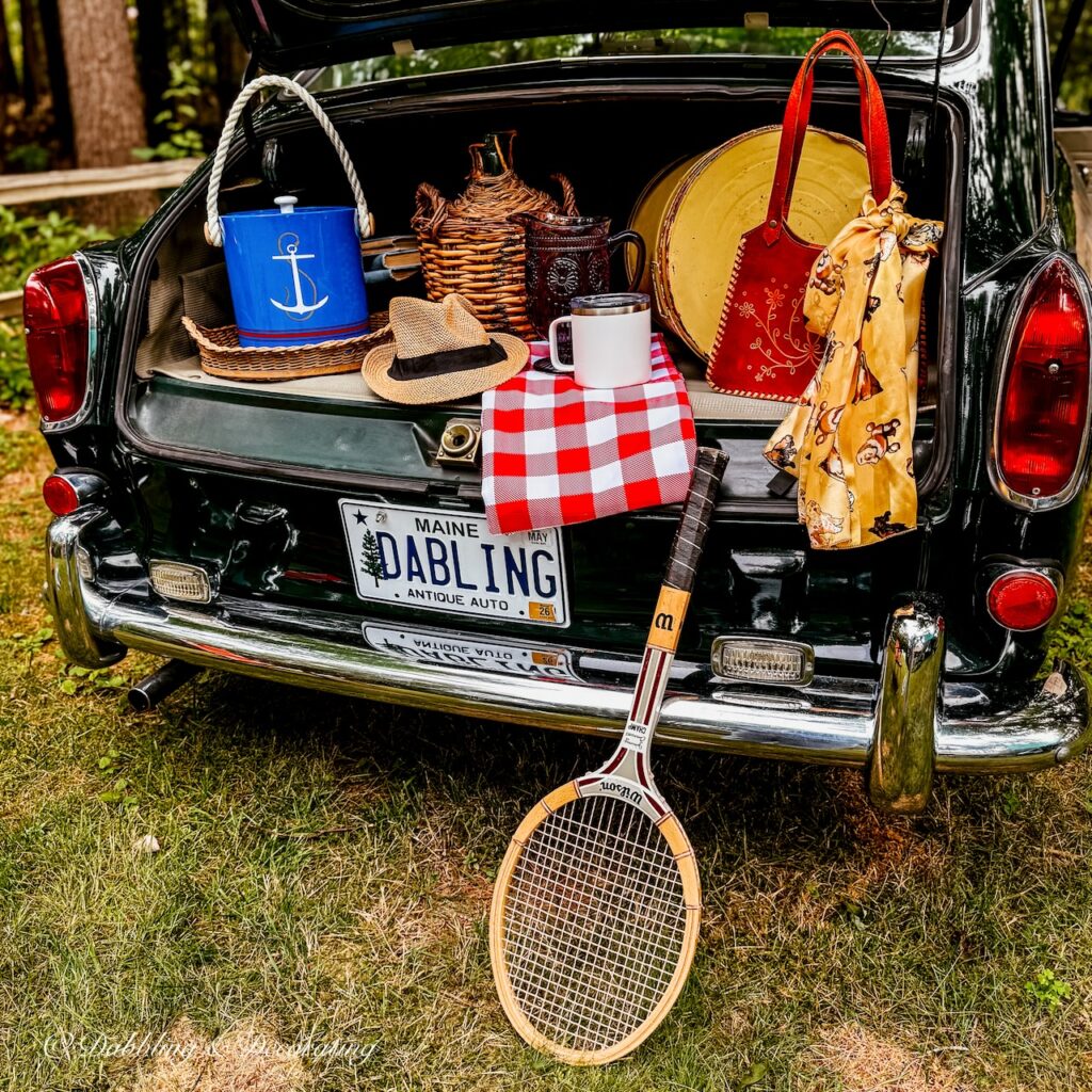 Vintage car trunk open with thrifted finds from a thrift store road trip.