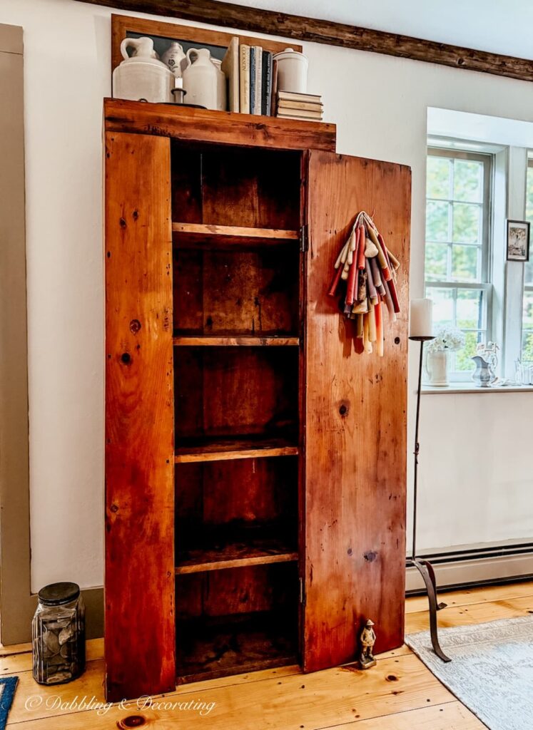 Antique wooden hutch emptied out to show you how to style an antique hutch with pewter.