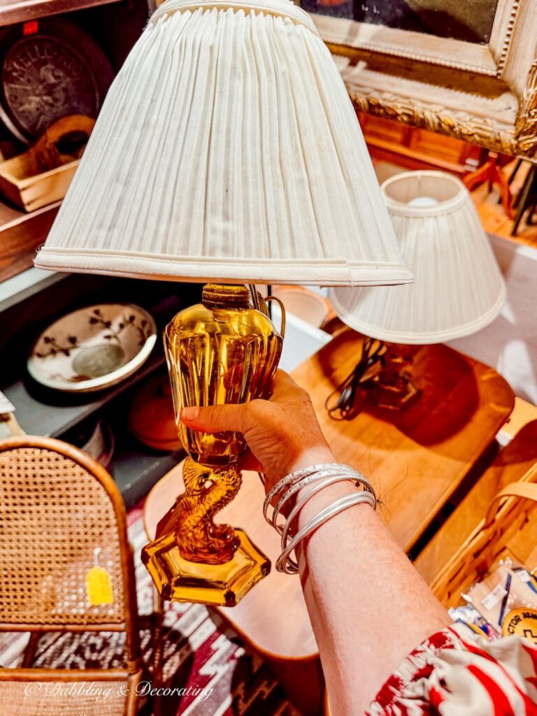 Amber glass lamp in hand at Wolfeboro Antiques in Wolfeboro, New Hampshire.