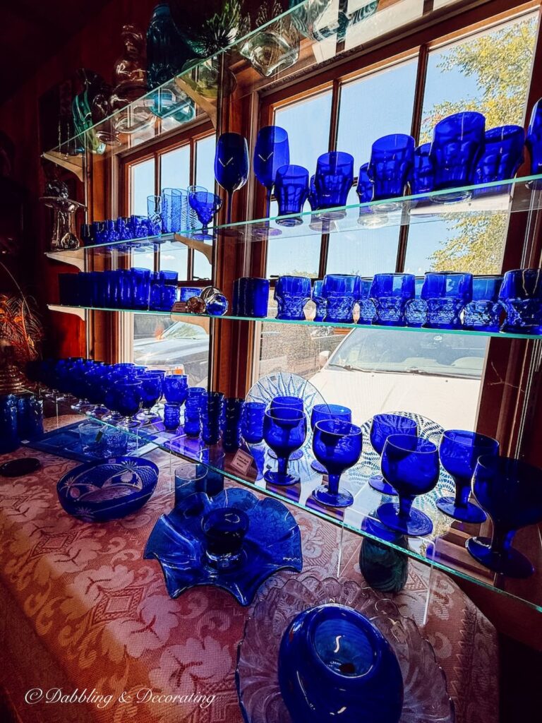 Vintage cobalt blue glassware on display in antique window.