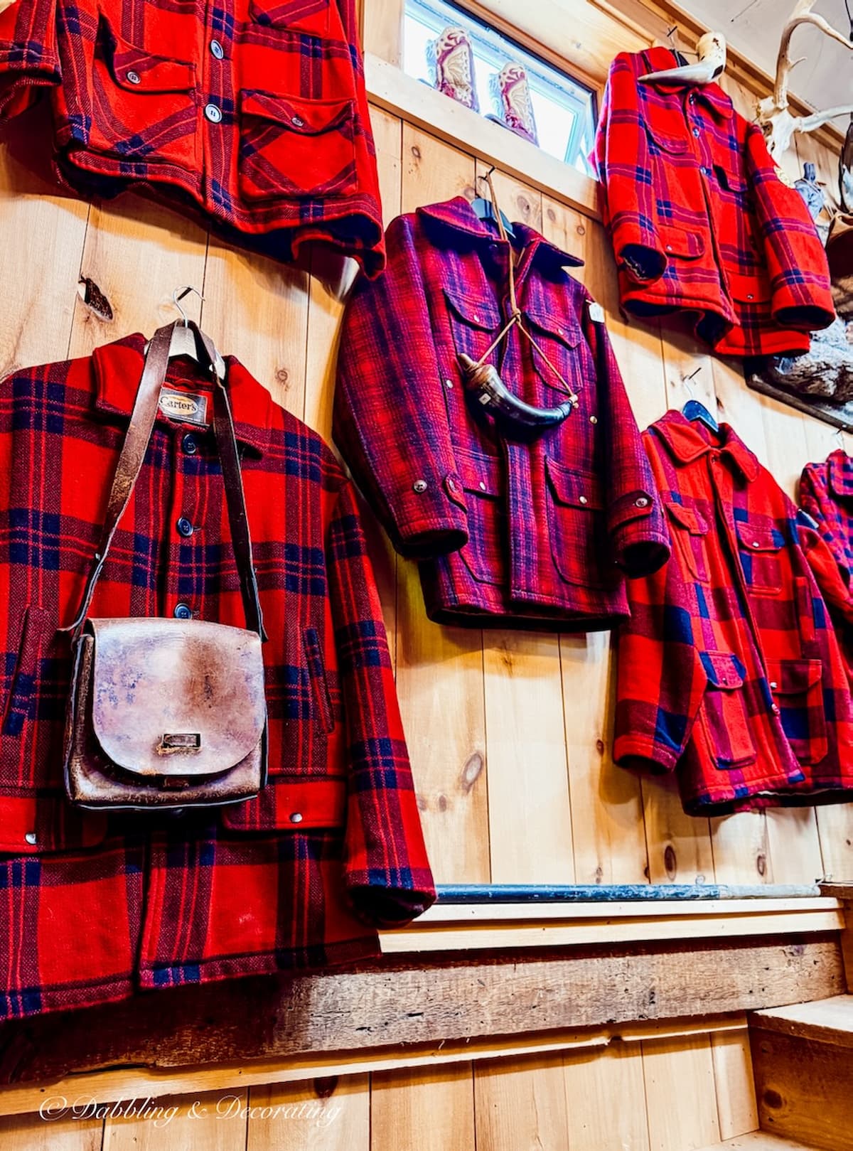 Red and black wool plaid mens jacket hanging on the wall at R.S. Butler's Trading Company.