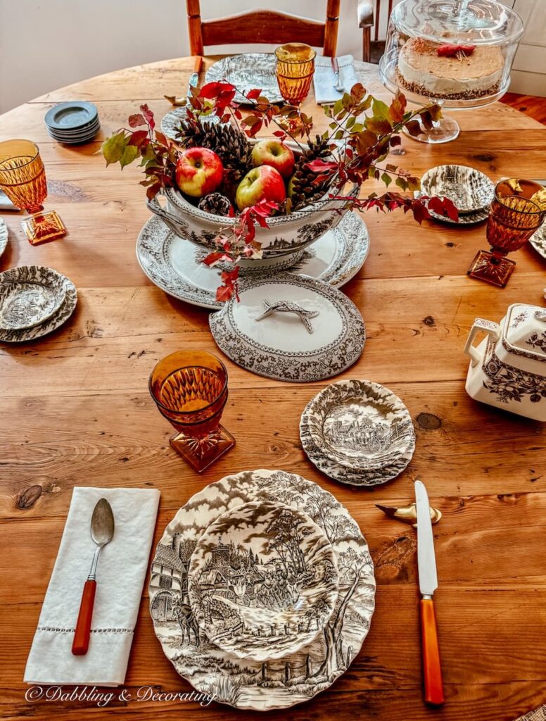 Brown and white vintage transferware displayed on round vs. rectangular table in dining room for fall display.