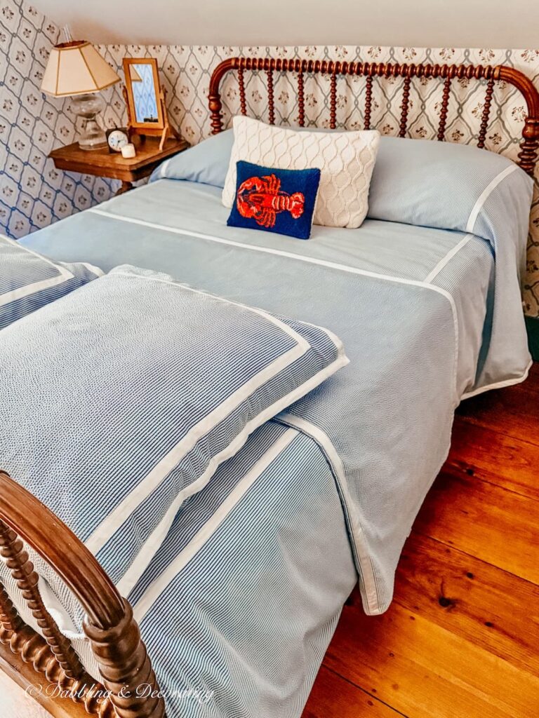 Antique Jenny Lind Bed makeover with seersucker bedding and lobster pillow in New England style guest bedroom.