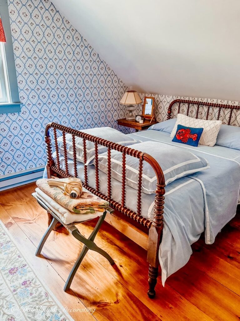 Antique spindle bed with seersucker bedding in coastal Maine guest bedroom.