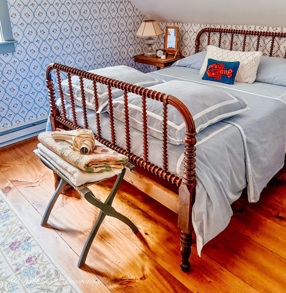 Antique spindle bed with seersucker bedding in coastal Maine guest bedroom.
