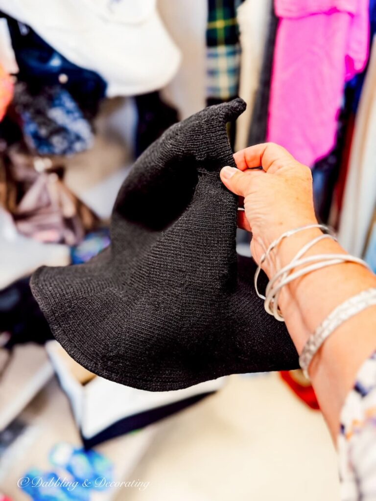 Black witches hat in hand at Goodwill Northern New England fall decor ideas.