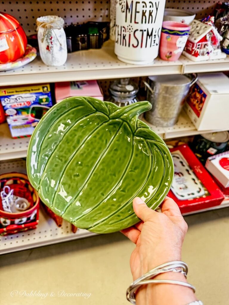 Green apple candy dish in hand at Goodwill Northern New England Store in Portsmouth, NH for fall decor ideas.
