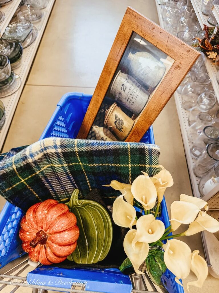 Blue shopping cart with yellow flowers, ceramic pumpkin blanket, and picture at Goodwill Northern New England fall decor ideas.