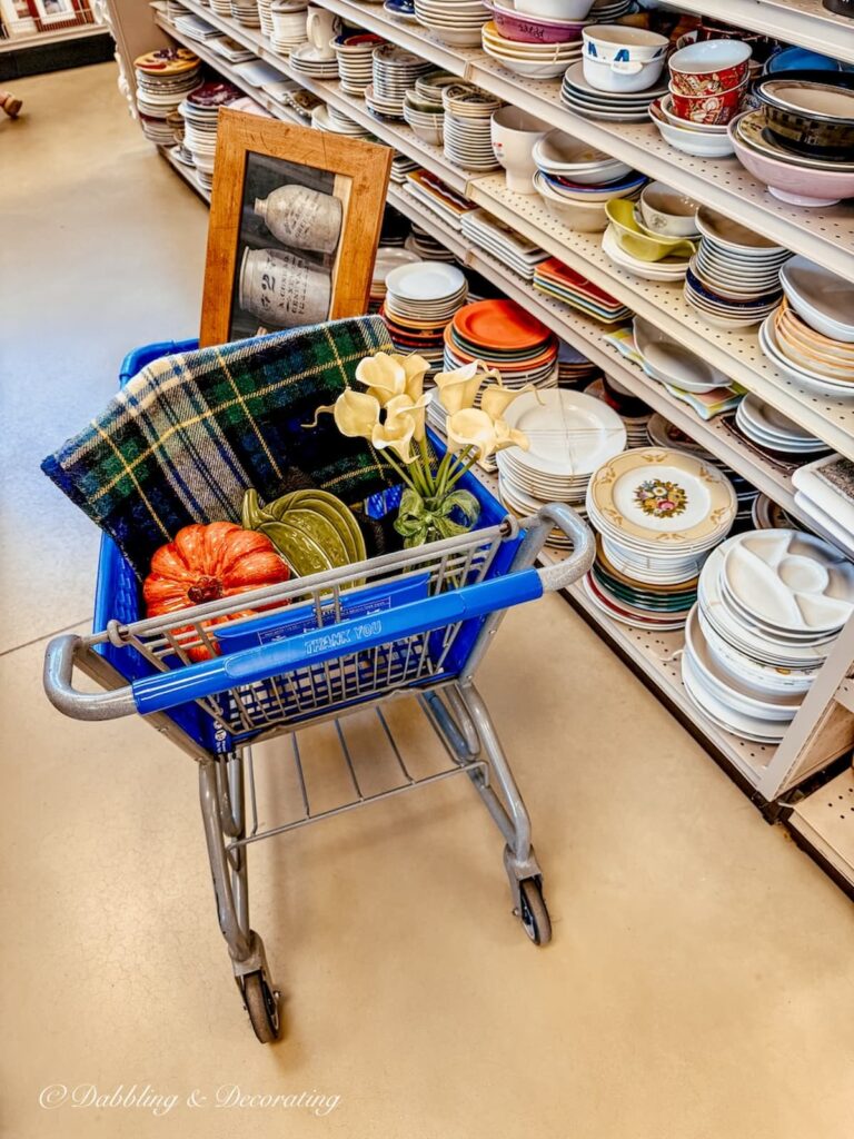 Blue shopping cart at Goodwill Northern New England Portsmouth, NH filled with fall decorating ideas.