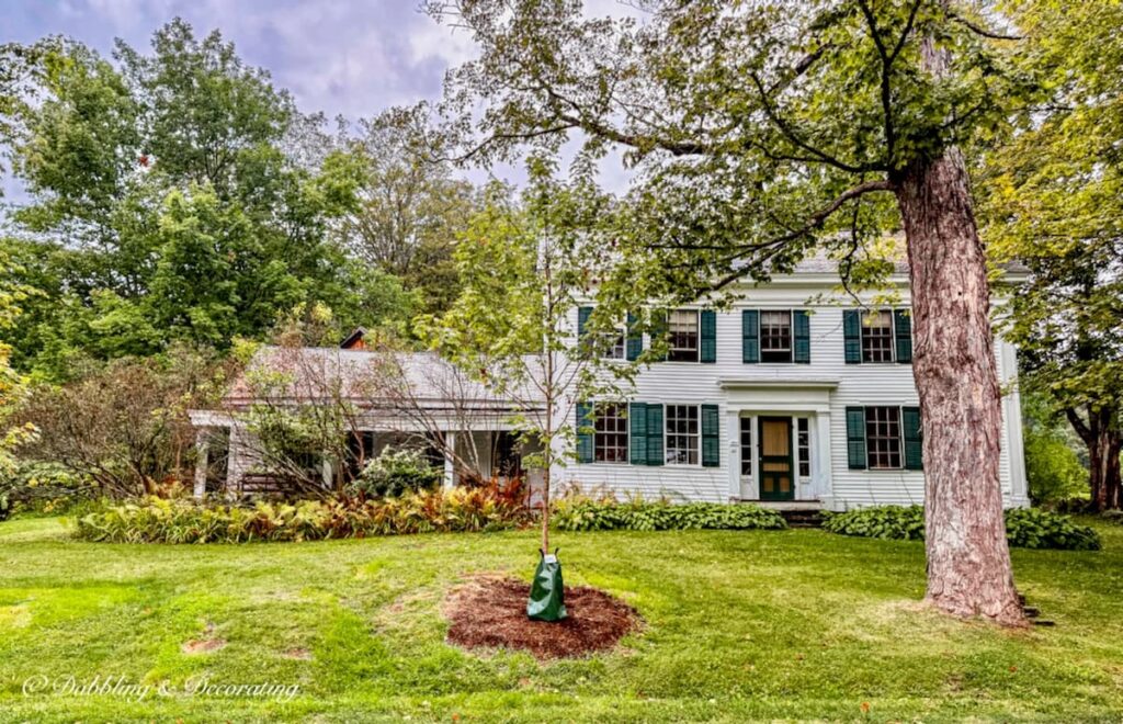 White Vermont farmhouse with classic Essex Green shutters and trim in fall decor ideas.