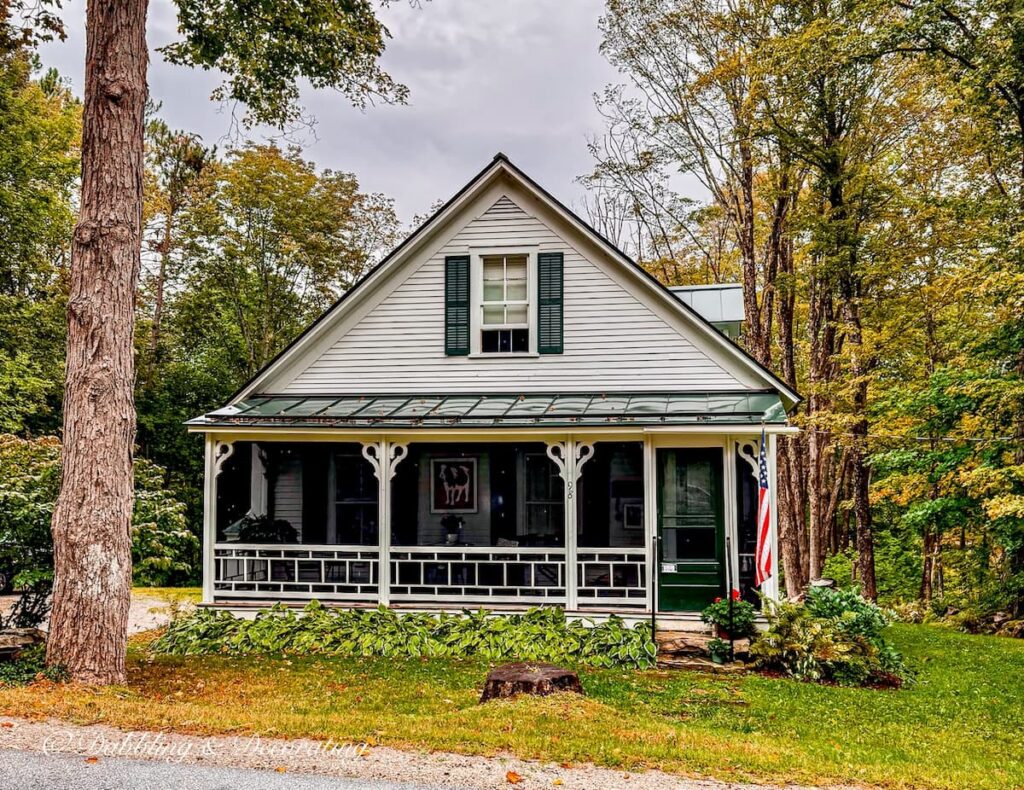 Small New England Farmhouse in Vermont with screened in Porch in white and green trim in Vermont.