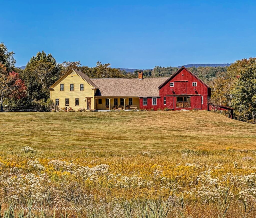 New England home in Vermont with red barn and yellow farmhouse in the mountains for fall decor ideas.