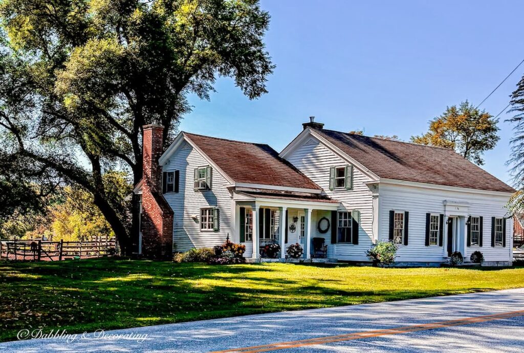 White New England Farmhouse with green shutters in Vermont with fall decor ideas.