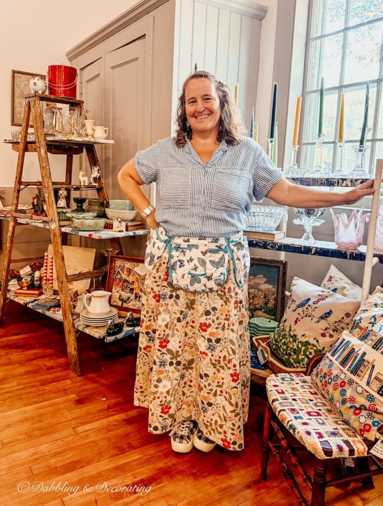 Woman standing in front of creative scaffolding vintage display at Vintage and Vogue Market in New Hampshire.