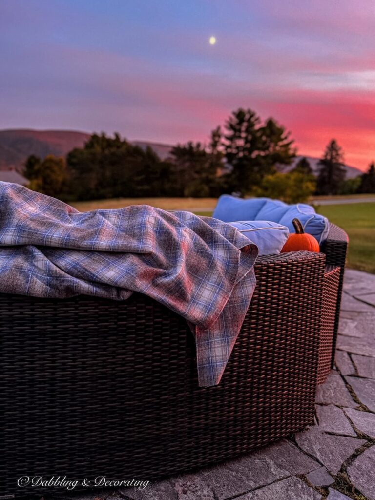 Backyard fire pit and patio with sectional seating at sunset in the mountains with a vintage Woolrich Swatch blanket.