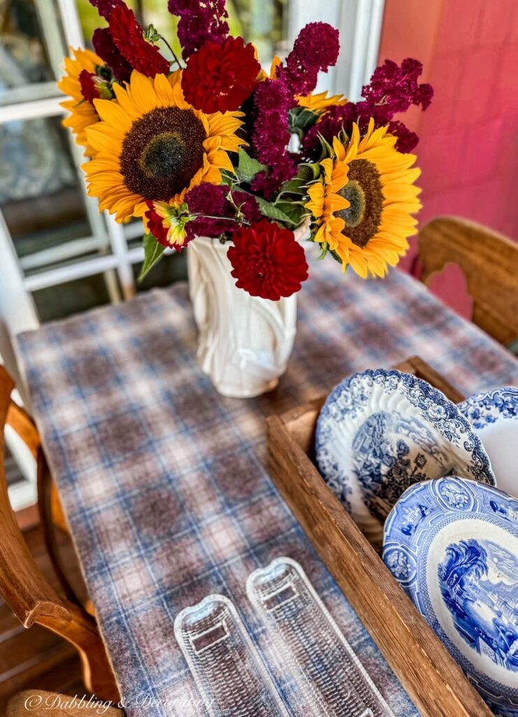 Blue and brown vintage plaid blanket on outdoor porch table with fall flowers and vintage finds from Vintage and Soul Market in Southern New Hampshire.