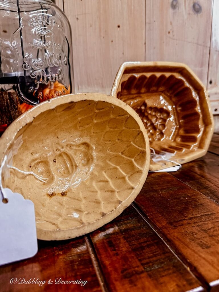 Vintage ironstone molds on antique store shelf in yellow and brown, perfect for Thanksgiving vintage decor ideas.