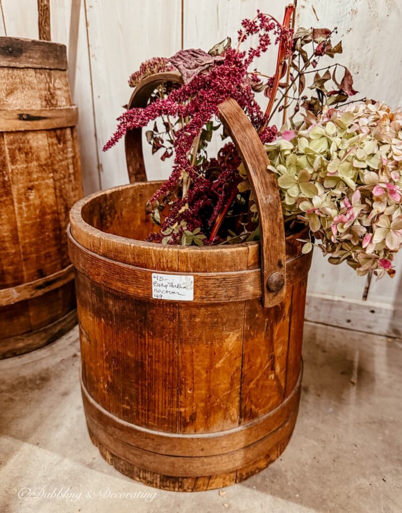 Antique wooden crate with handle and mauve and purple fall flowers for a stunning Thanksgiving vintage decor piece.