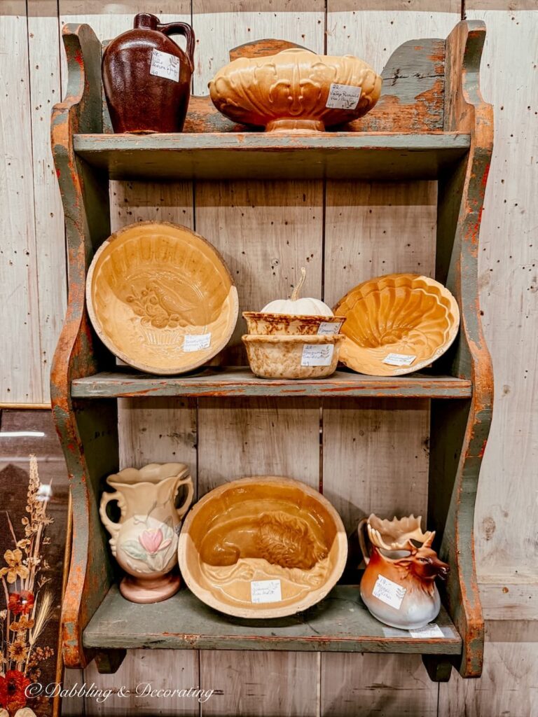 Antique blue wall shelving with vintage yellow ware pieces on display for thanksgiving vintage decor.