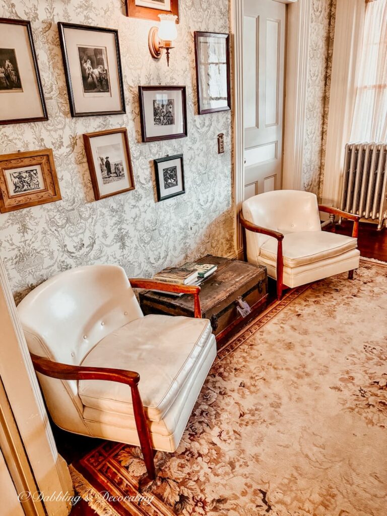 Upstairs sitting room with antique white chairs and wall hangings on second floor of Wainwright Inn while antiquing in the Berkshires in Massachusetts.