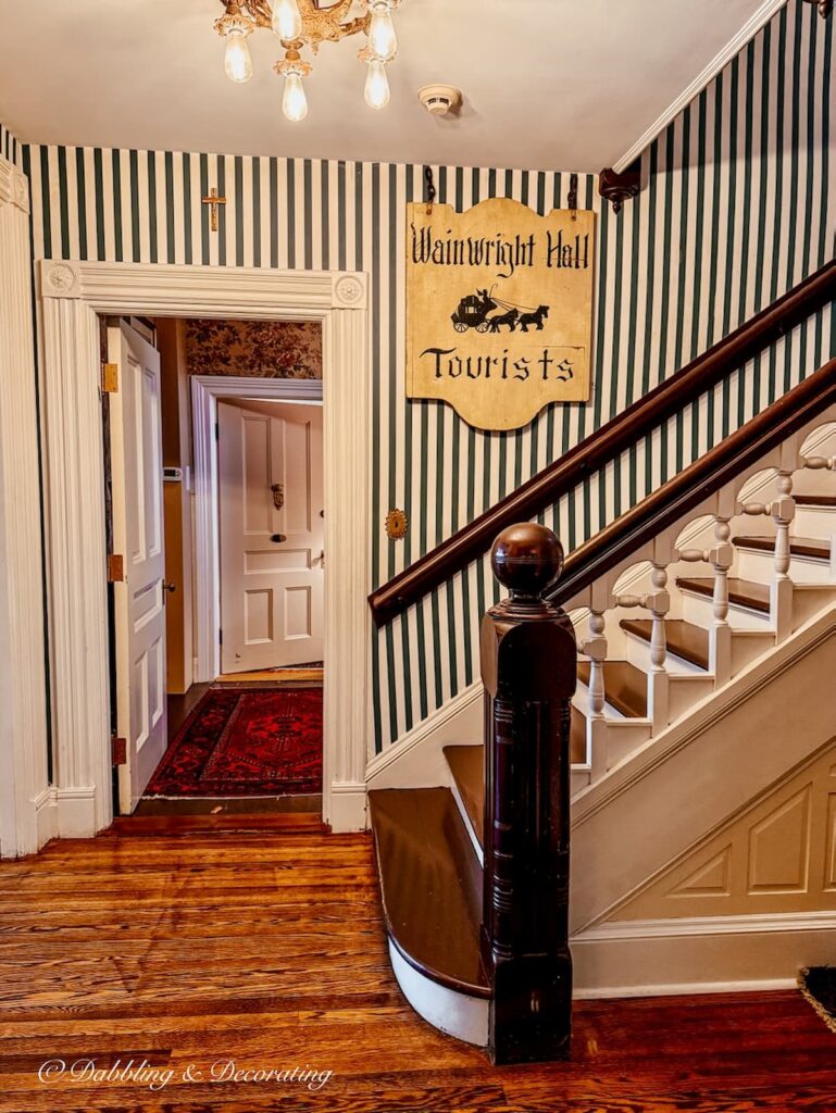 Entryway and staircase at the Wainwright Inn in Great Barrington, Massachusetts with antique sign Wainwright Hall Tourists.