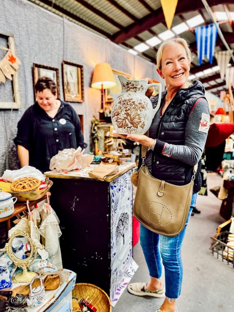 Bernadette, a friend with a transferware pitcher in her hand at Vintage Market Days Vermont smiling.