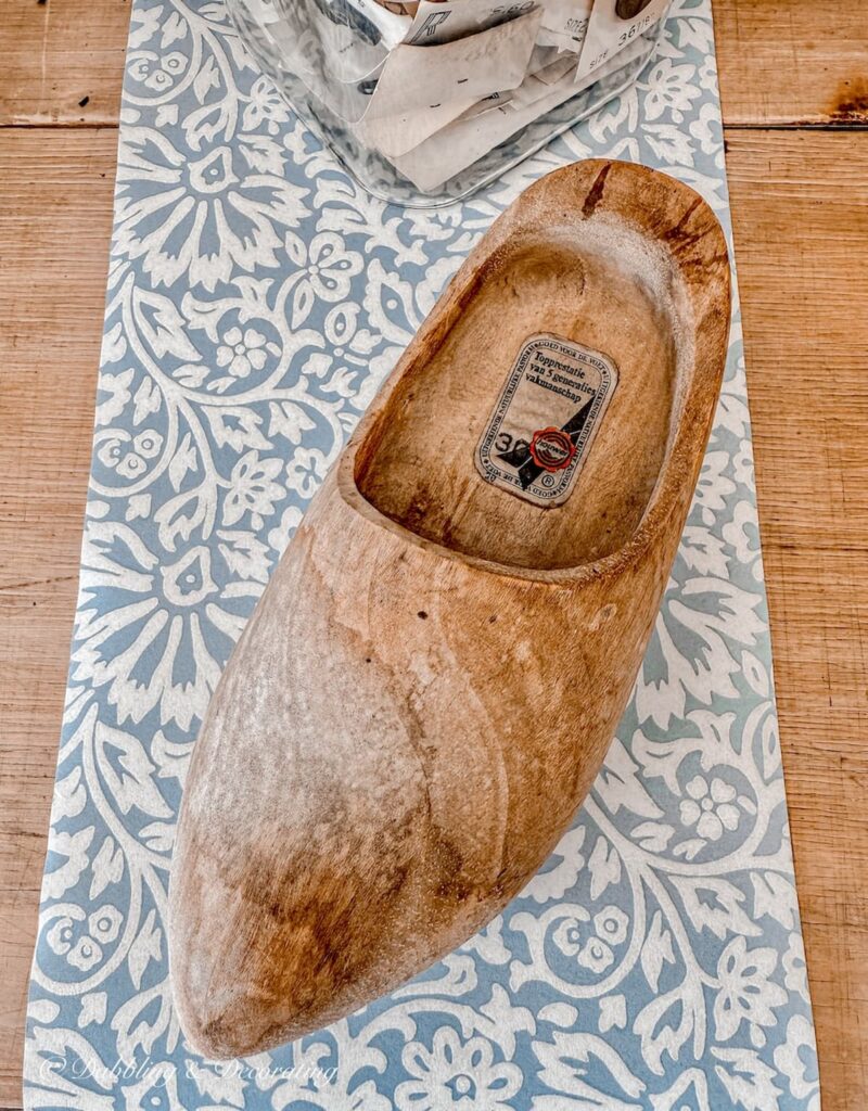 One Dutch wooden clog on craft table waiting to be painted, all prepped.