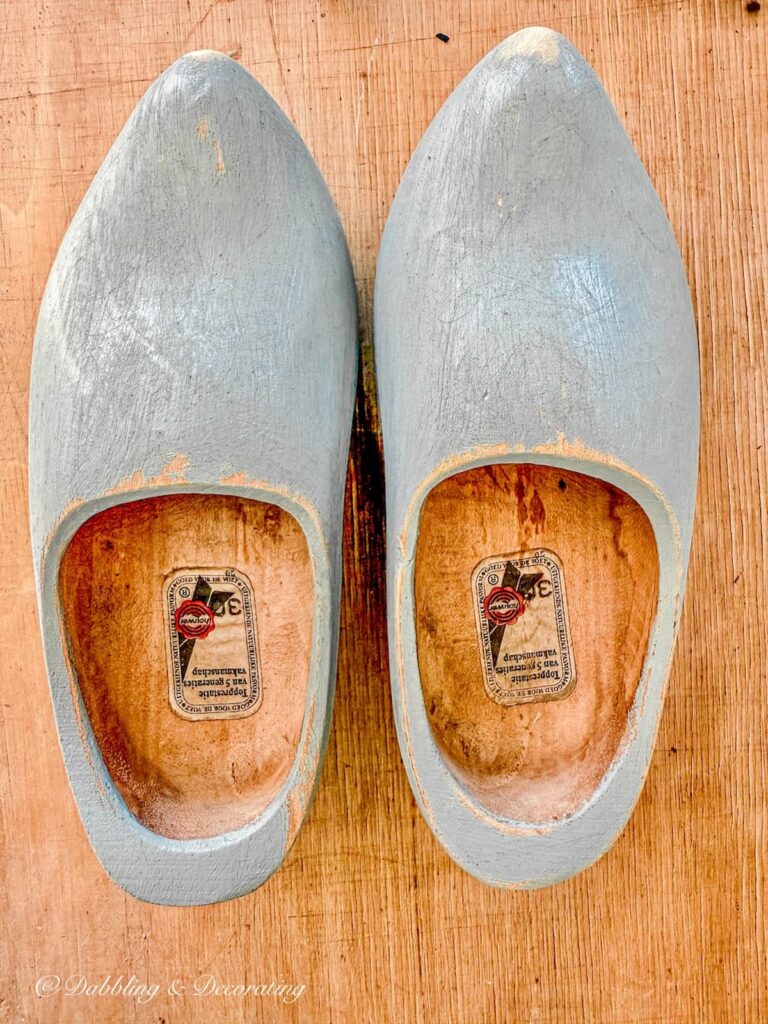 A pair of Dutch wooden clogs painted blue and sanded to look worn.
