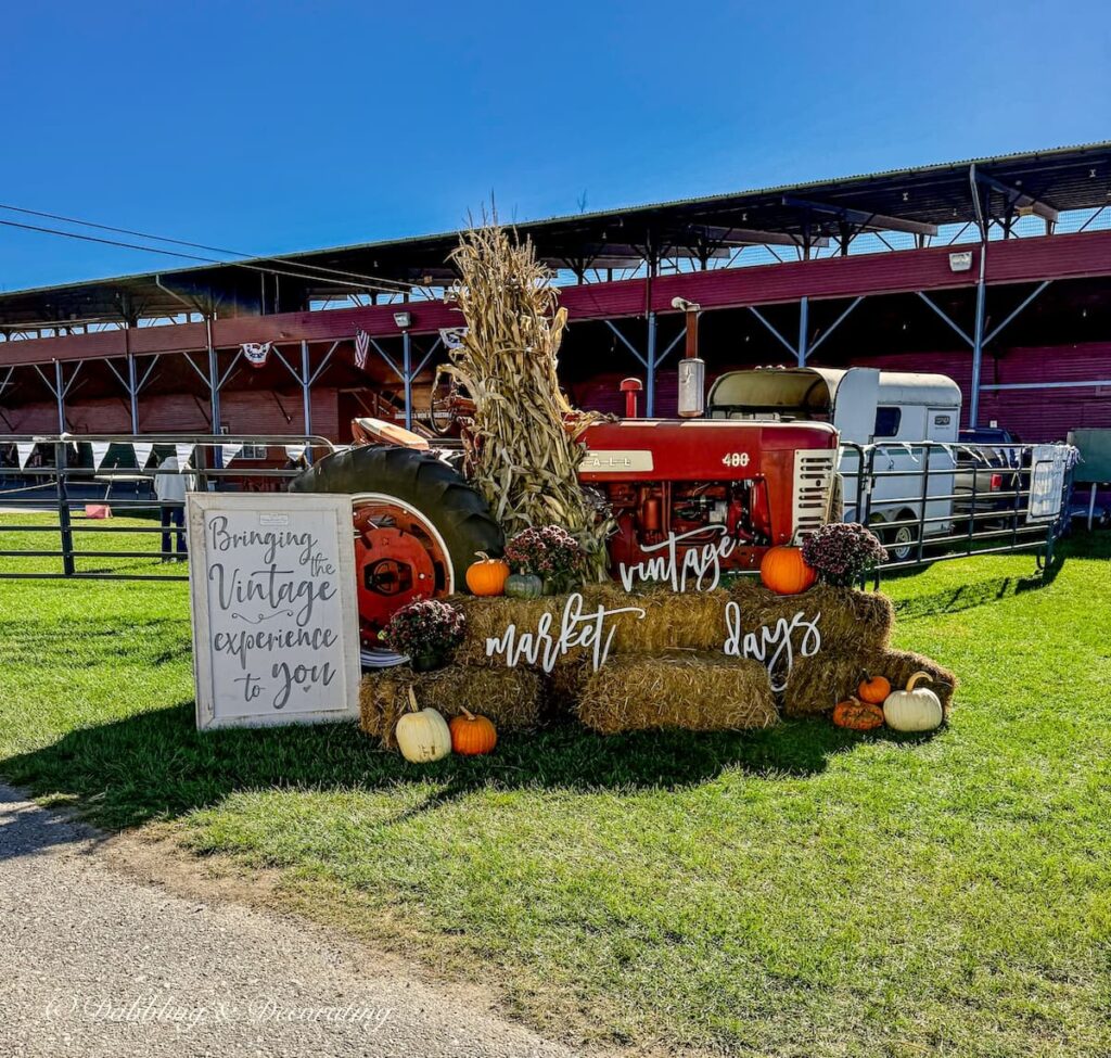 Vintage Market Days Vermont with vintage red tractor and entry sign "Bringing the Vintage to You".