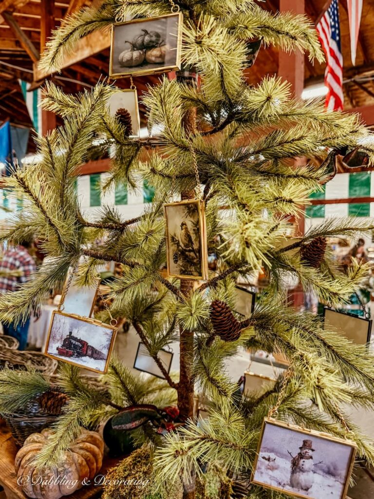 Faux Christmas tree at a vintage market with vintage gold frames as tree ornaments in vintage Christmas decor.