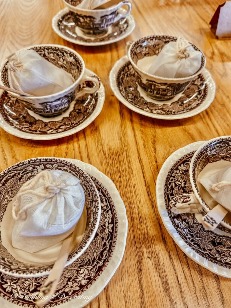 Set of brown and white vintage transferware tea cup and saucer with bags of potpourri and popsicle sticks for vintage Christmas decor ideas.