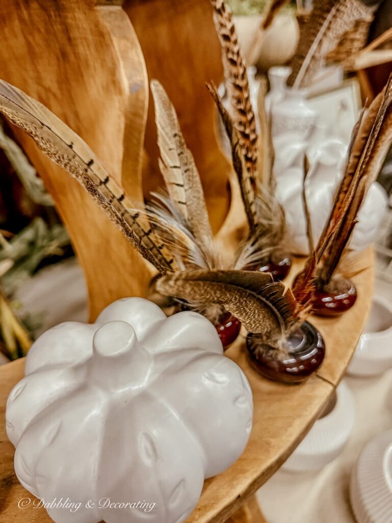 Pheasant feathers displayed in old door knobs for vintage holiday decor ideas.
