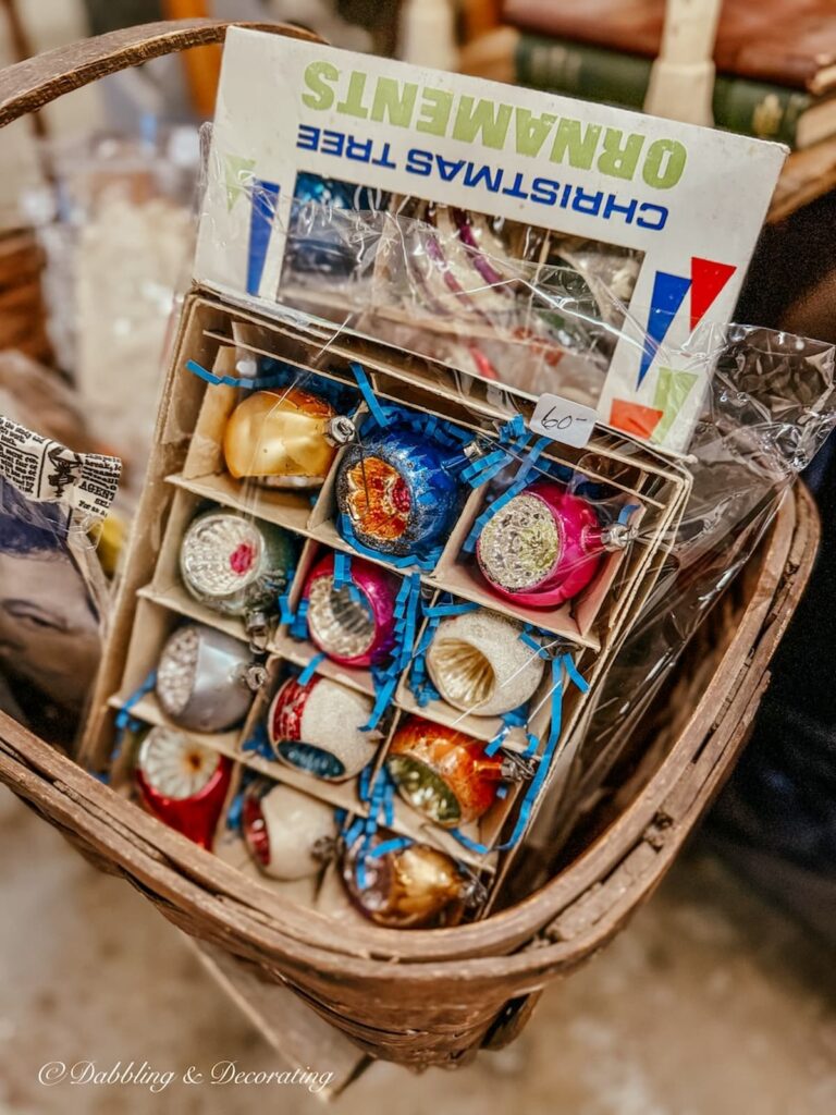 Colorful Vintage Christmas bulb ornaments in a box at a vintage market.
