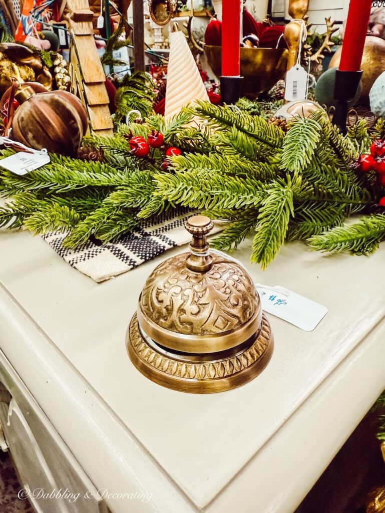 Shopkeeper's bell in vintage Christmas decor on shelf at Vintage Market Days.