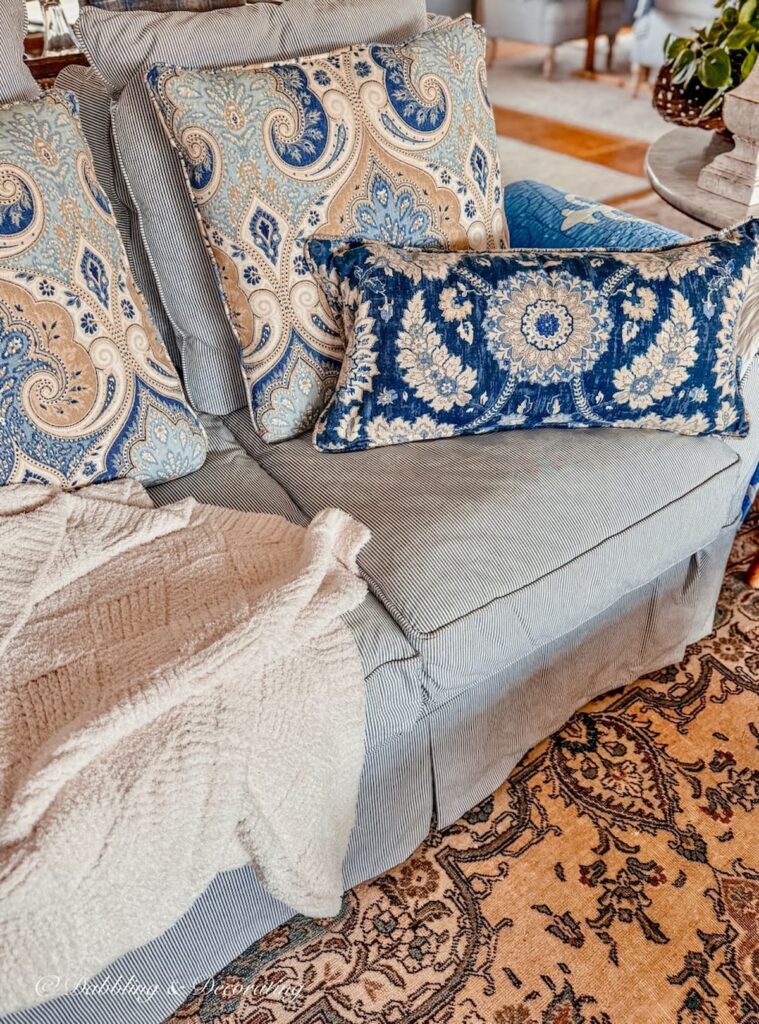 Blue pinstripe love seat with custom slipcovers and mix and max custom slip covered pillows.