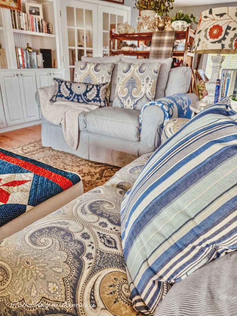Cozy cottage living room with blue and brown mix and match patterns as vintage home decor gifts.