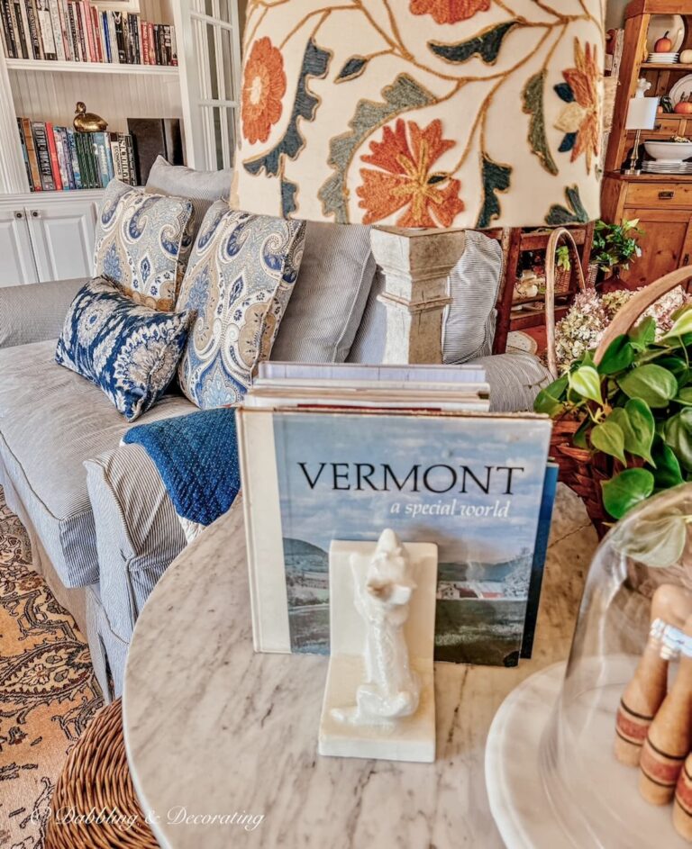 Cozy living room at Vermont home with mix and match custom slipcovered pillows and side table with Vermont book as vintage home decor gifts.
