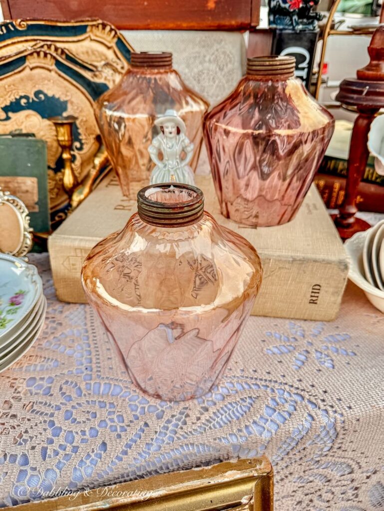pink glass lanterns at flea market antique vendor booth.