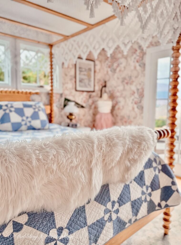 Spindle pine canopy bed with blue and white quilt and white sheepskin decor ideas draped over the bed rail in Vermont master bedroom.