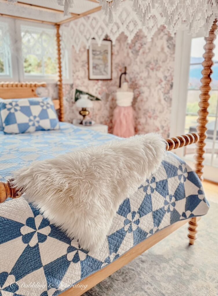 Spindle pine canopy bed with blue and white quilt and white sheepskin decor ideas draped over the bed rail in Vermont master bedroom.